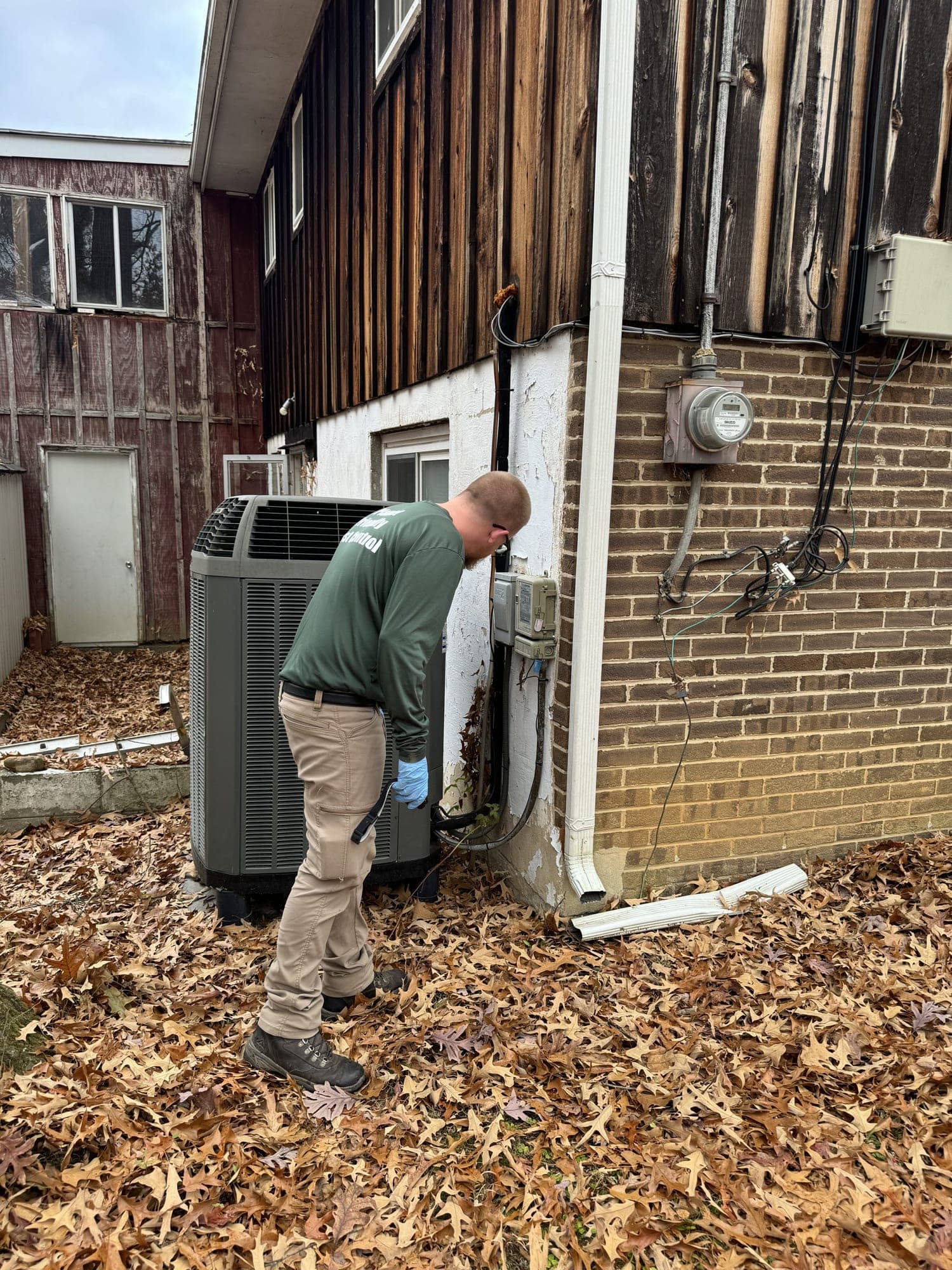 A Planet Friendly technician inspecting a home exterior